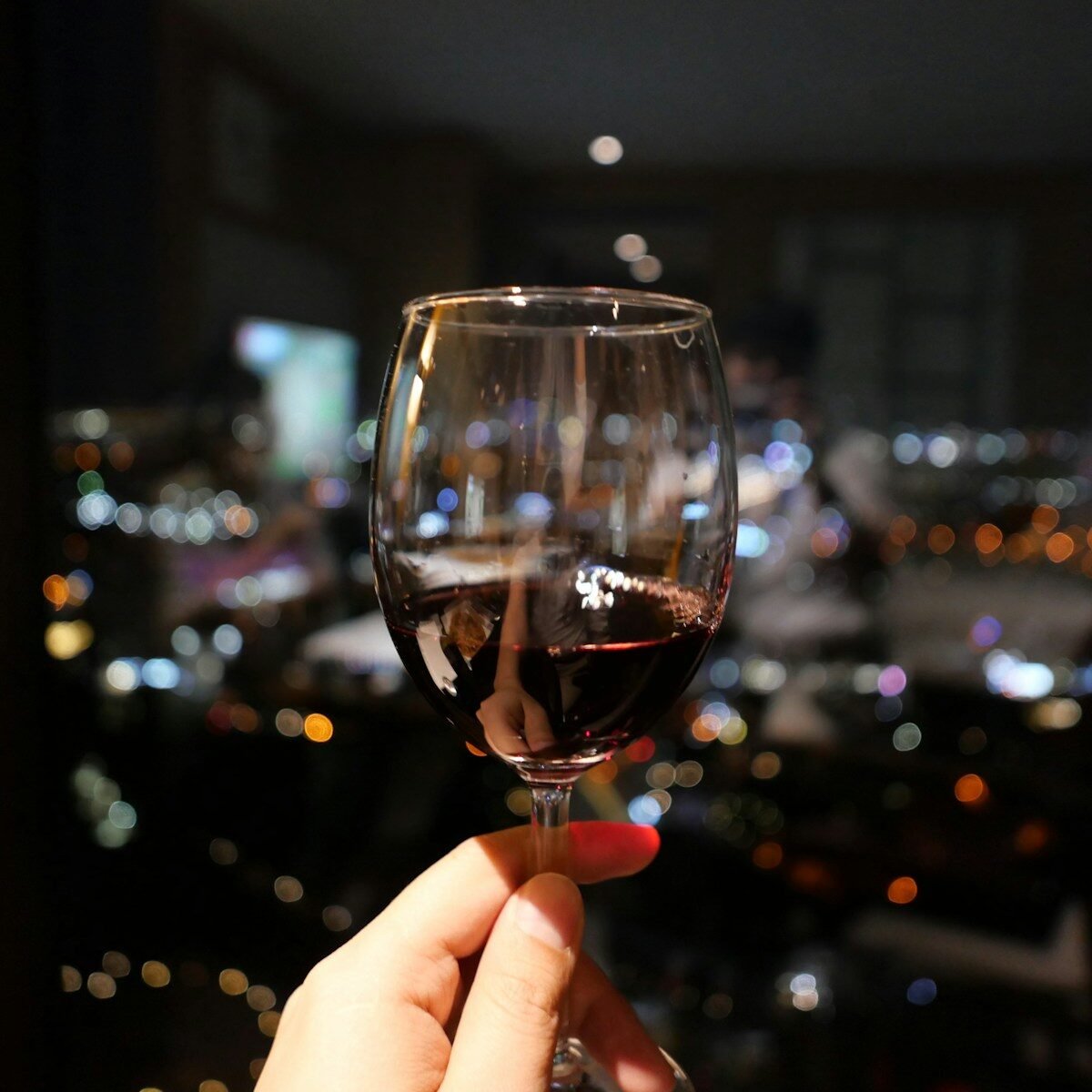 a person holding a wine glass in their hand